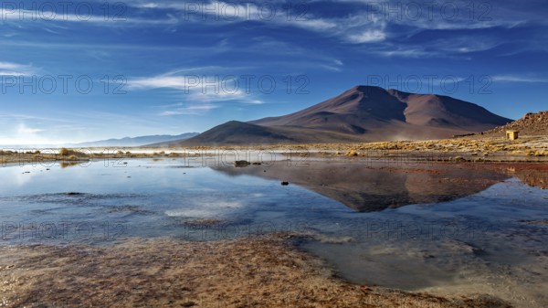 Peaceful mountain landscape with a clear lake and clouds in the sky creating a tranquil atmosphere, The thermal springs of Polques in Bolivia