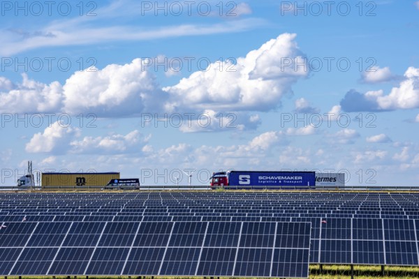 86, 5 MW peak ground-mounted photovoltaic systems, by RWE, with over 141, 000 solar modules, on a verge, over 1 km long, along the A44 motorway near Bedburg, at the Jackerath junction, recultivated open-cast mining site, field with sunflowers, North Rhine-Westphalia, Germany
