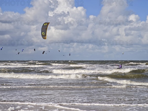 California kitesurfing Masters 2025 on the edge of the UNESCO World Heritage Wadden Sea, North Sea, kitesurfing sport, flying kites, fun, competition, strong wind, high swell, whitecaps, beach, summer, sunshine, blue sky, white clouds, Ording, Sankt Peter-Ording, Schleswig-Holstein, Germany