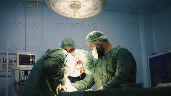 Several doctors performing a complex surgical operation inside an operating room for a displaced patient. Aleppo, Syria. October 18, 2022, Aleppo, Syria