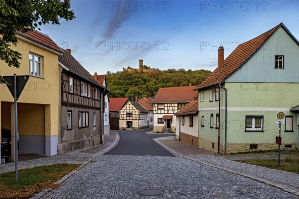 Historic village with half-timbered houses, castle ruins on a green hill and cobbled street, the village of Mühlburg in Thuringia near Erfurt
