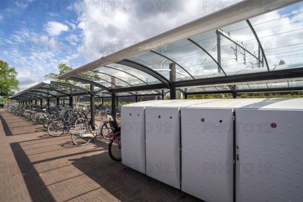 Bicycle parking spaces and boxes on the cycle path in the east of Utrecht, at Utrecht-Lunetten railway station, direct connection of the cycle path to the railway station and bus station, covered bicycle stands, on the Maarschalkerweerdpads cycle path, Netherlands
