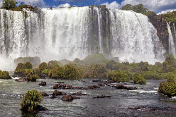 Close-up of a powerful waterfall with lush vegetation and spray, The Iguazu Falls between Argentina and Brazil
