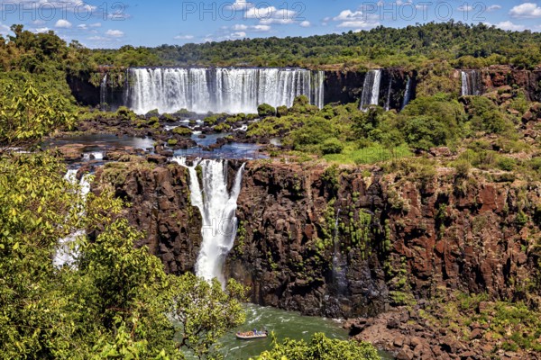 Wide waterfall with rocks and dense forest, peaceful and spectacular scenery, The Iguazu Falls between Argentina and Brazil