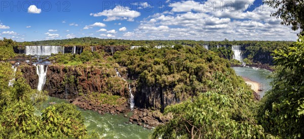 Sweeping views of waterfalls and dense forest under a blue sky, The Iguazu Falls between Argentina and Brazil