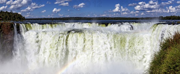 Impressive panoramic view of a chain of waterfalls under a cloudy sky, The Iguazu Falls between Argentina and Brazil