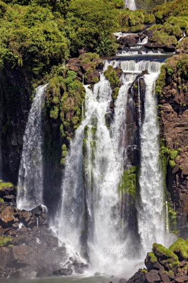Waterfall gurgling over moss-covered rocks, surrounded by a steep landscape, The Iguazu Falls between Argentina and Brazil
