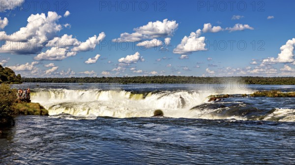 Wide waterfall under a cloudy sky in a beautiful landscape, The Iguazu Falls between Argentina and Brazil
