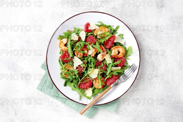 Fresh shrimp salad with arugula, grapefruit, and parmesan served in a bowl
