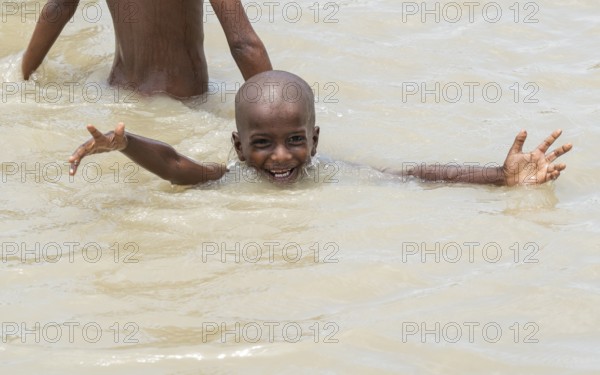Children bathe in the Brahmaputra River to seek relief from the intense summer heat in Guwahati, India, on June 26, 2025