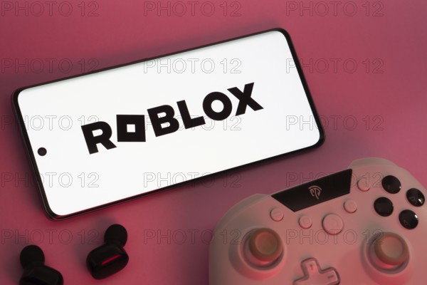 Dhaka, Bangladesh- 26 July 2025: A close-up of a gamepad with the Roblox seen on smartphone