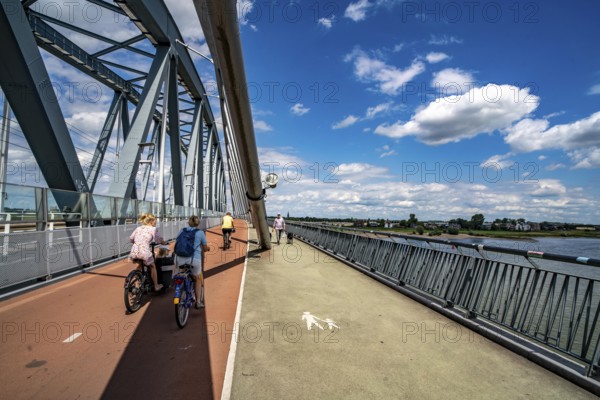 Cycle and pedestrian bridge Snelbinder Brug, over the river Waal near Nijmegen, was added to the existing railway bridge, fast cycle path connection from the city centre of Nijmegen and the new housing estates in the Waalsprong district, Netherlands