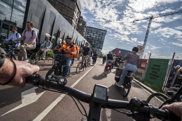 Ride your bike on the central cycle path on Lange Viestraat, Vredenburg, in the city centre of Utrecht, lanes for pedestrians, cyclists and public transport vehicles are separated, heavy cycle traffic, Netherlands