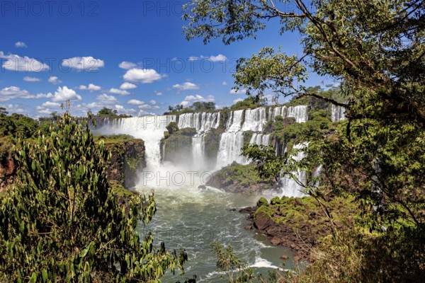 Waterfalls in the heart of the jungle under a clear sky, The Iguazu Falls between Argentina and Brazil