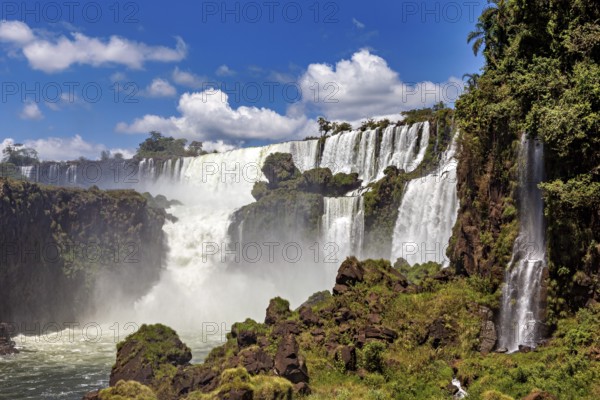 Waterfalls with spraying water mist and lush vegetation, The Iguazu Falls between Argentina and Brazil