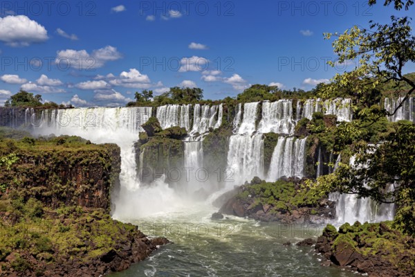 Impressive waterfalls with cliffs and spray under a blue sky, The Iguazu Falls between Argentina and Brazil