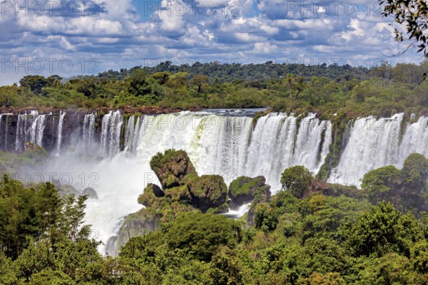 Majestic waterfall surrounded by dense forests and cloudy skies, The Iguazu Falls between Argentina and Brazil