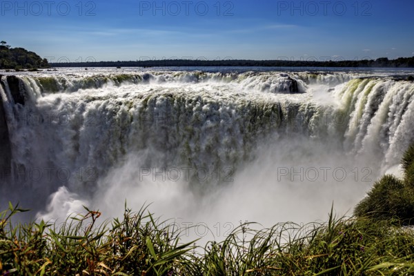 Impressive waterfall plunges into the depths, surrounded by rising spray, The Iguazu Falls between Argentina and Brazil