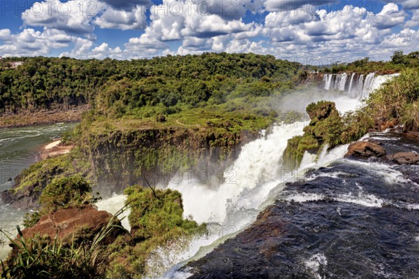 Impressive waterfall with foaming river and lush vegetation, The Iguazu Falls between Argentina and Brazil