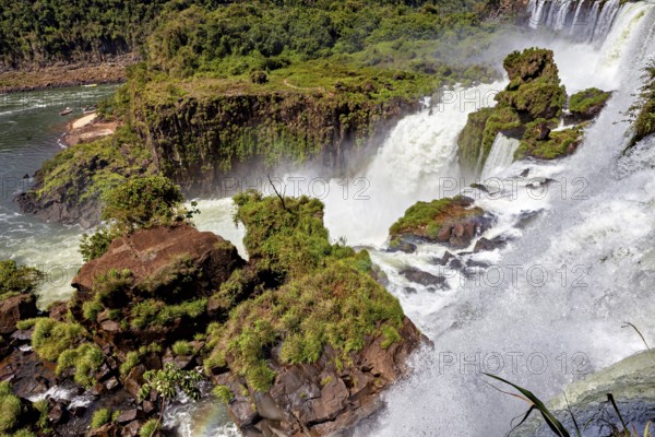 River landscape with waterfall, surrounded by dense vegetation and rocks, The Iguazu Falls between Argentina and Brazil