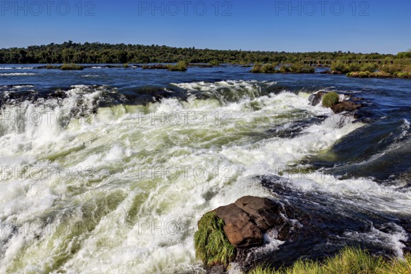 Slightly turbulent river with small rapids, the waterfalls of the Iguazu between Argentina and Brazil