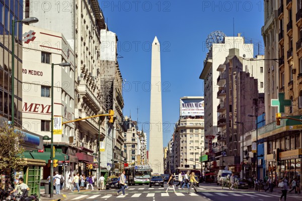 A busy street scene in daylight in Buenos Aires with the obelisk in the centre, The great obelisk in the city of Buenos Aires Argentina