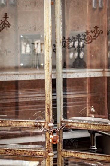 Old rusted metal gate with chain and padlock in an urban environment, La Recoleta cemetery in Buenos Aires Argentina