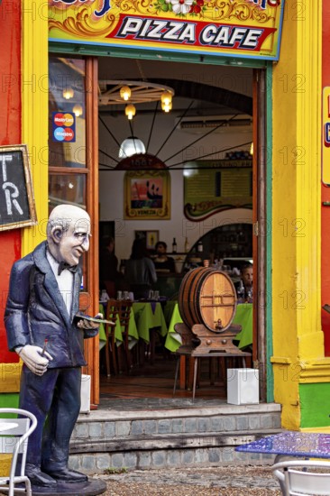 A café with a colourful façade and a sculpture in front of the entrance, inviting interior, The colourful city and tango district of La Bocca in Buenos Aires Argentina