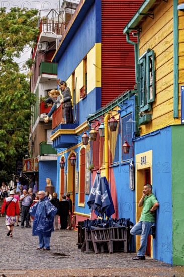 People stroll in front of colourful buildings with a dynamic, lively atmosphere, The colourful city and tango district of La Bocca in Buenos Aires Argentina