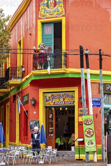 A lively pizza café with bright colours and balconies in a busy city street, the colourful city and tango district of La Bocca in Buenos Aires Argentina