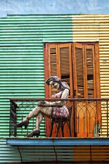 Female figure on a balcony in front of a striped façade, The colourful city and tango district of La Bocca in Buenos Aires Argentina