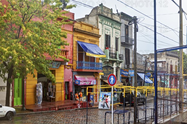 Lively street with colourful buildings and wet cobblestones on a cloudy day, The colourful city and tango district La Bocca in Buenos Aires Argentina