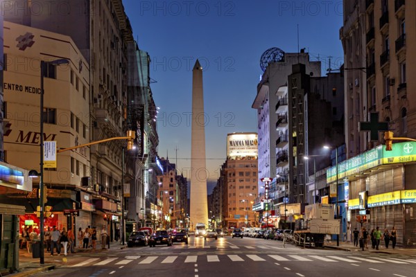 Twilight view of a busy city street, the obelisk illuminated by lights, The great obelisk in the city of Buenos Aires Argentina