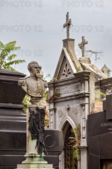 Monumental bust of a man in a cemetery, surrounded by historic tombs, La Recoleta Cemetery in Buenos Aires Argentina