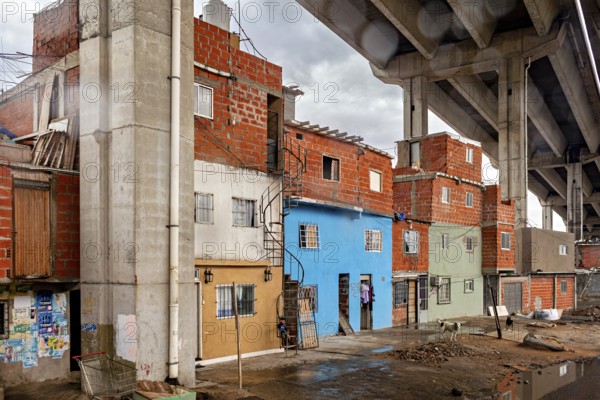 Brick houses under a bridge with a dull sky in an urban environment, The colourful city and tango district La Bocca in Buenos Aires Argentina