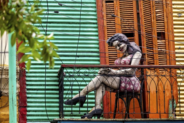 Sculpture of a woman on a decorative balcony with a coloured wall, The colourful city and tango district of La Bocca in Buenos Aires Argentina
