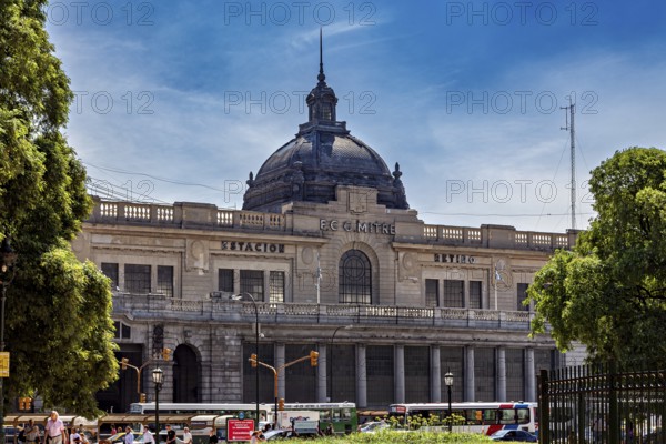 A large railway station with a dome, surrounded by trees and traffic under a blue sky, The city of Buenos Aires in Argentina