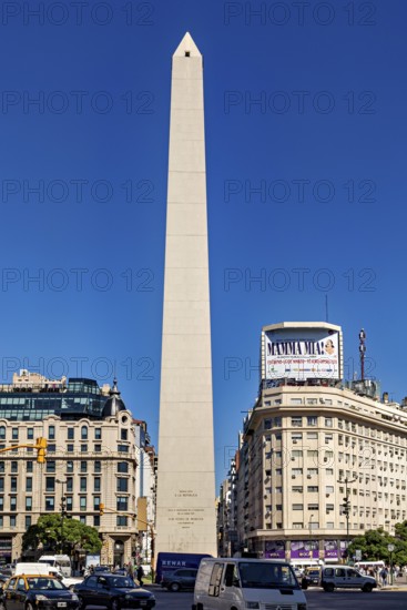 A tall obelisk stands between modern buildings under a clear blue sky, The Great Obelisk in the city of Buenos Aires Argentina