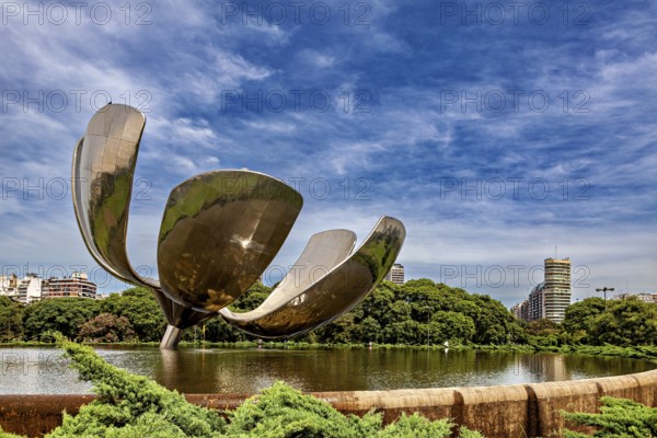 Imposing metallic flower with urban background, surrounded by a pond and trees, The lotus flower in Buenos Aires Argentina