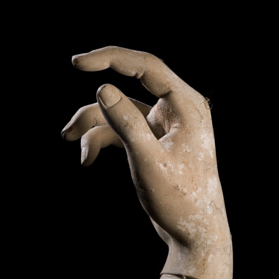 A detailed view of a mannequin hand with fingers slightly curled, creating a graceful pose against a dark background, showcasing the artistry in design and craftsmanship