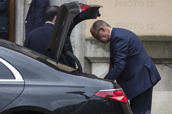 Friedrich Merz (CDU, German Chancellor) takes something out of a car boot in front of the joint meeting with Emmanuel Macron (President of the French Republic) at Villa Borsig in Berlin on 23 July 2025