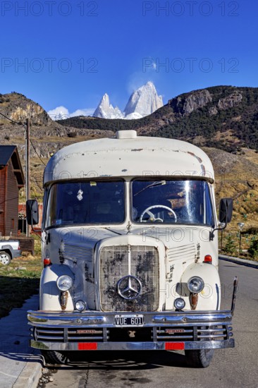 A vintage bus in front of a snow-covered mountain landscape, taken from the front view on a road, A historic Mercedes bus in El Chalten in Patagonia Argentina