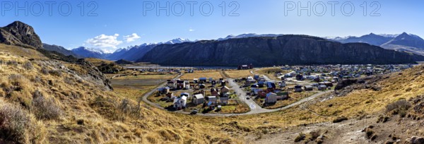 Panoramic view of a village in the valley, surrounded by high mountains and dry grassland under a clear sky, The village of El Chalten in Patagonia Argentina