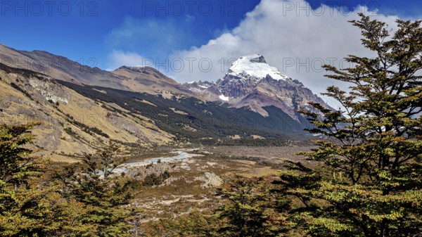 Wide valley with a river, surrounded by mountain peaks and wooded areas, The Patagonian landscape near El Chalten in Argentina