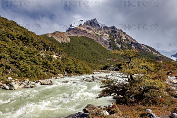 River flows through mountainous landscape with cloudy sky, The landscape of Patagonia in Argentina