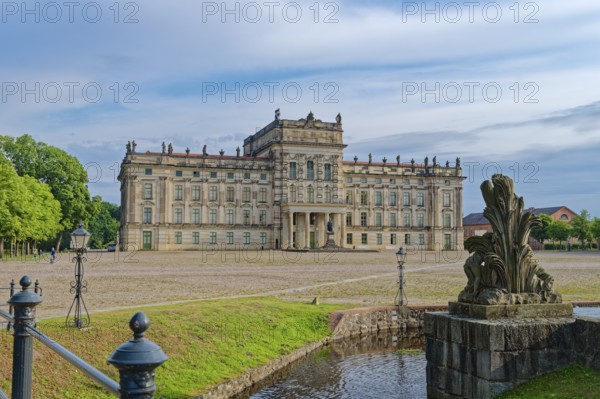 Ludwigslust Palace, built in the Baroque period and characterised by Classicism, with the palace square. In the foreground is the basin, a water basin with cascades and stone figures. Ludwigslust, Mecklenburg-Western Pomerania, Germany
