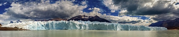 Large-scale panorama of a distant glacier with draped clouds and mountains, The glacier of Perito Moreno in Argentina