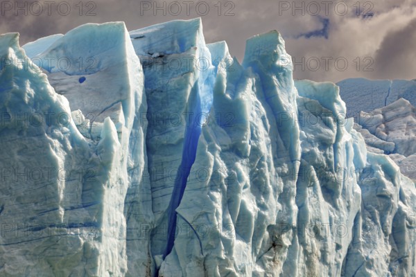 Majestic glacier wall under a cloudy sky in different shades of blue, The blue ice of the Perito Moreno Glacier in Patagonia Argentina