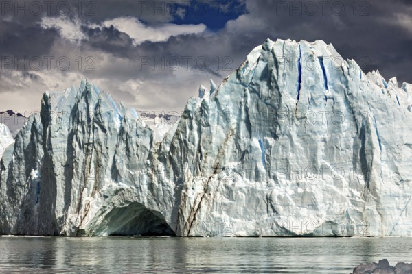 Majestic glacier front under a cloudy sky with mountains in the background, The glacier of Perito Moreno in Argentina