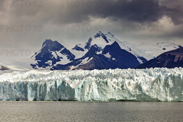 A powerful view of snow-covered mountains and glaciers under a gloomy sky, The Perito Moreno glacier in Argentina